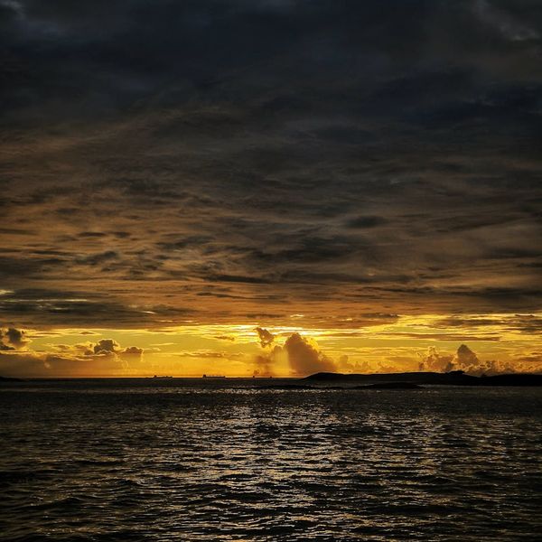 A serene landscape at dusk with calm water reflecting the sky.