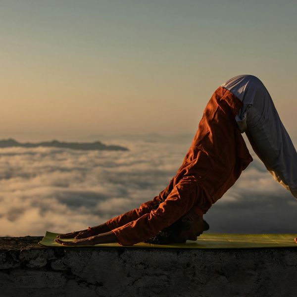 Silhouette of a person stretching during sunrise, showing flexibility.